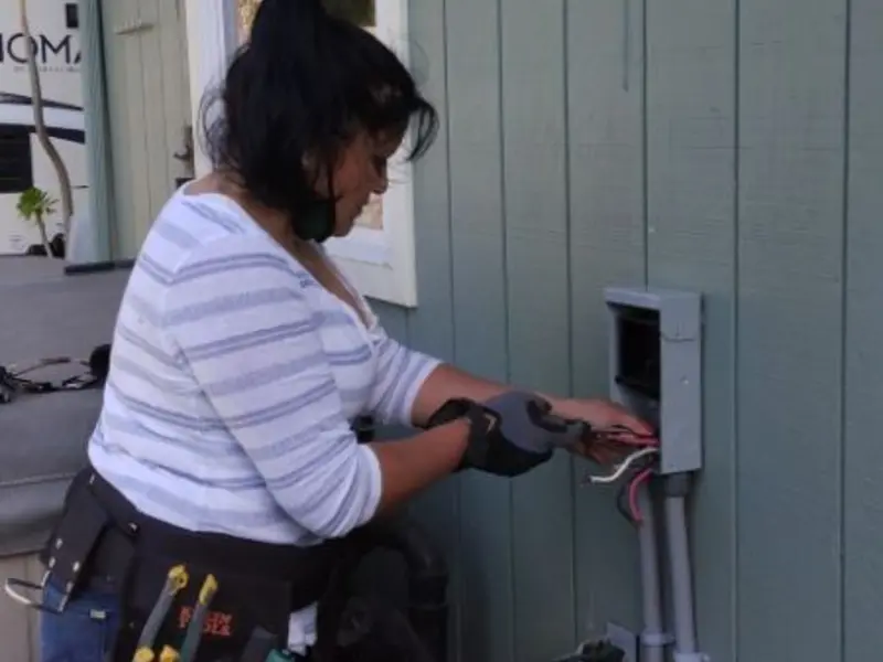 Licensed electrician wiring an exterior subpanel in Walton